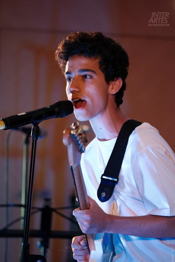 Musician singing and playing guitar during an Interartes performance