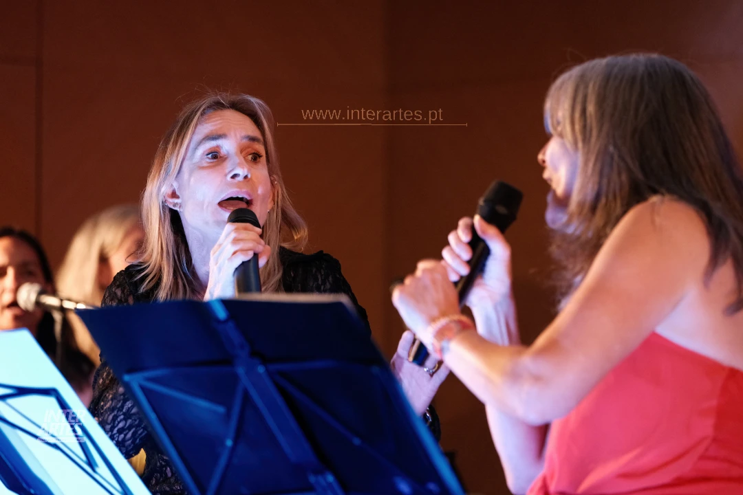Duas participantes do Coro Interartes a cantar em palco